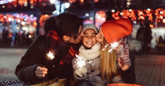 parents kissing child on cheek during the holiday season