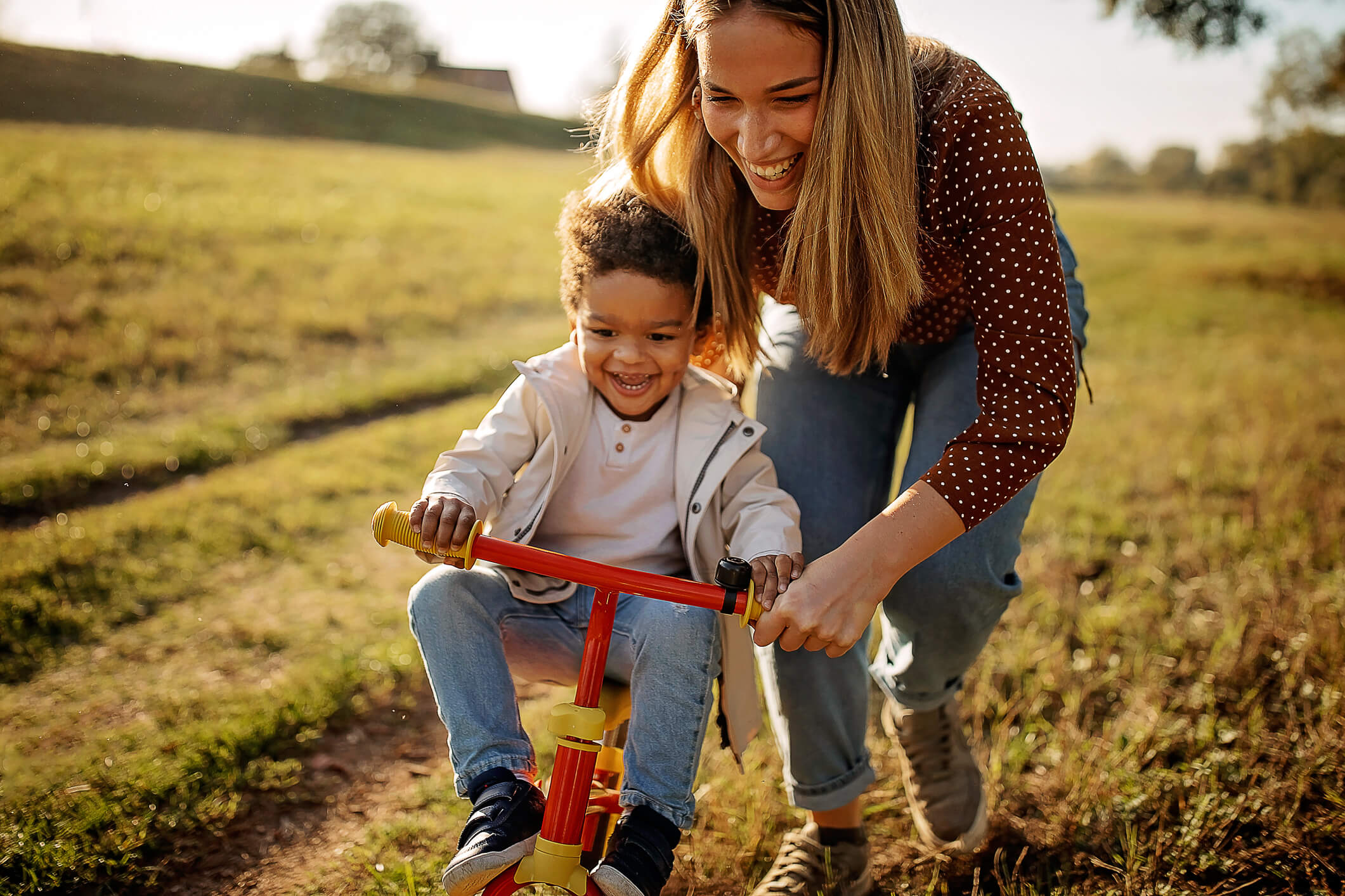Mom helping son bike in field